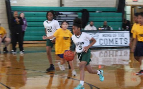  Dossin basketball player dribbles down court.